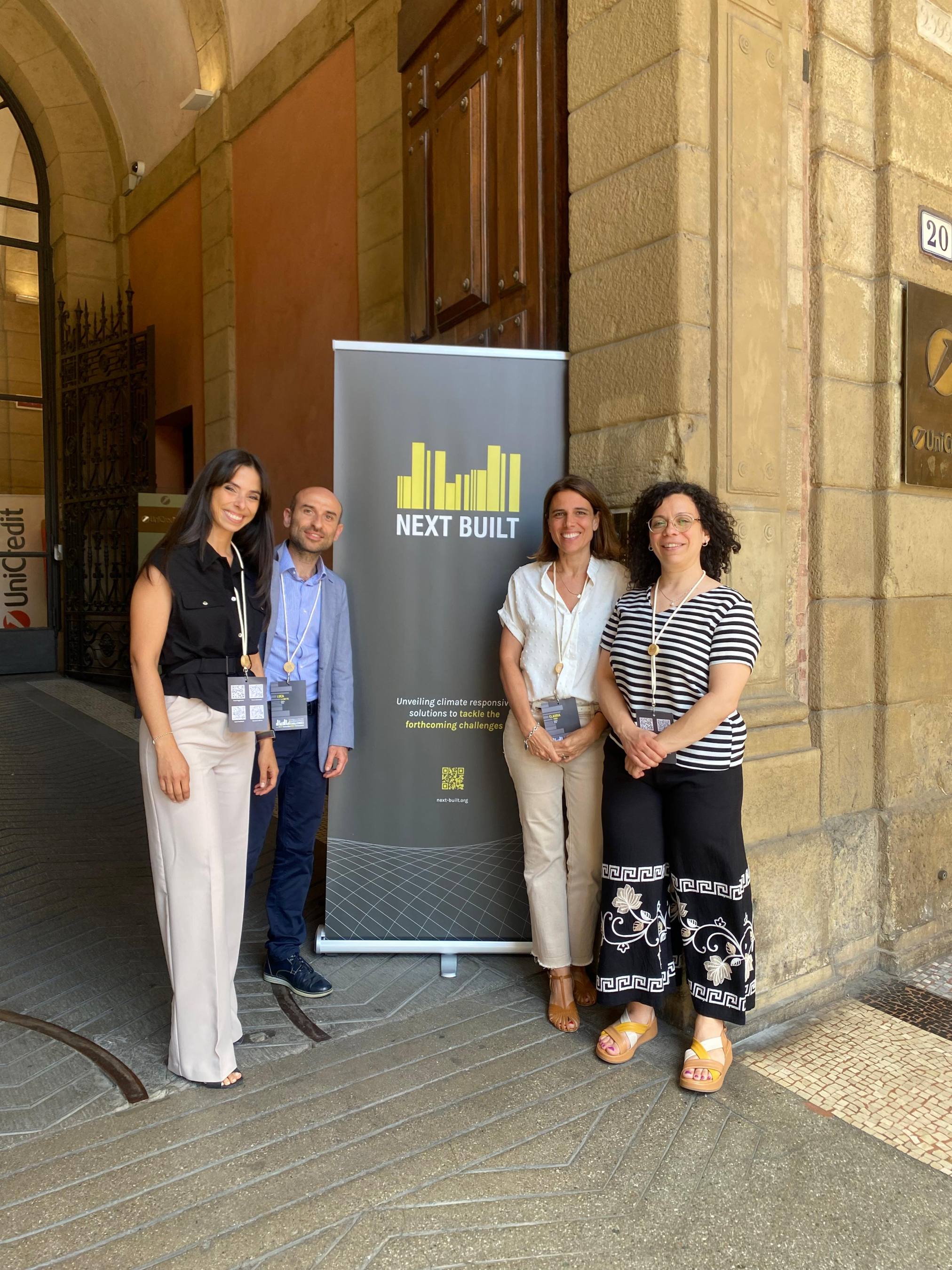 I ricercatori ENEA Veronica Pagano, Luca La Notte, Claudia Toro e Francesca Paoloni davanti al poster della conferenza Next Built 2026
